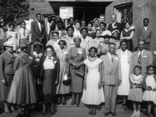 Black and white photo of a group of people posing in an outdoor setting