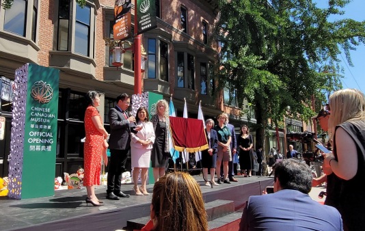 Group of people on a stage at an outdoor event in a city street