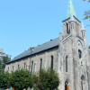 A large stone church surrounded by trees