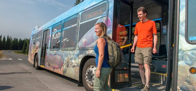 Two people getting off of a bus