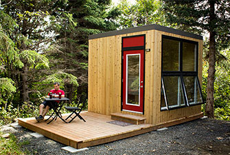 A visitor sits at a table on the deck of a MicrOcube.