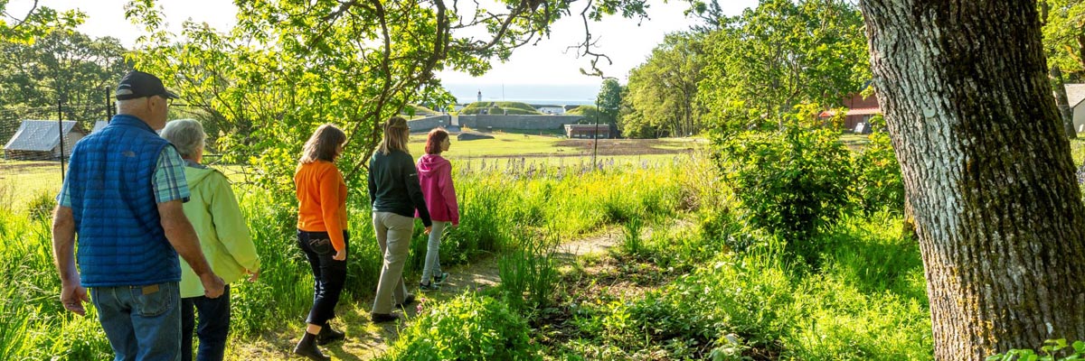 Parks Canada interpreter guiding visitors on a walk through the learning meadow.