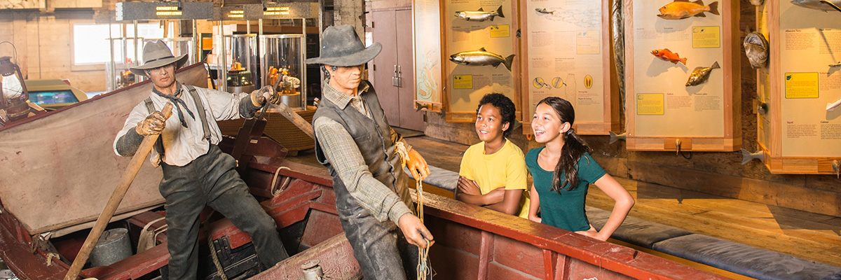 A boy and girl learn about fishing heritage at the fishing-boat diorama exhibit.