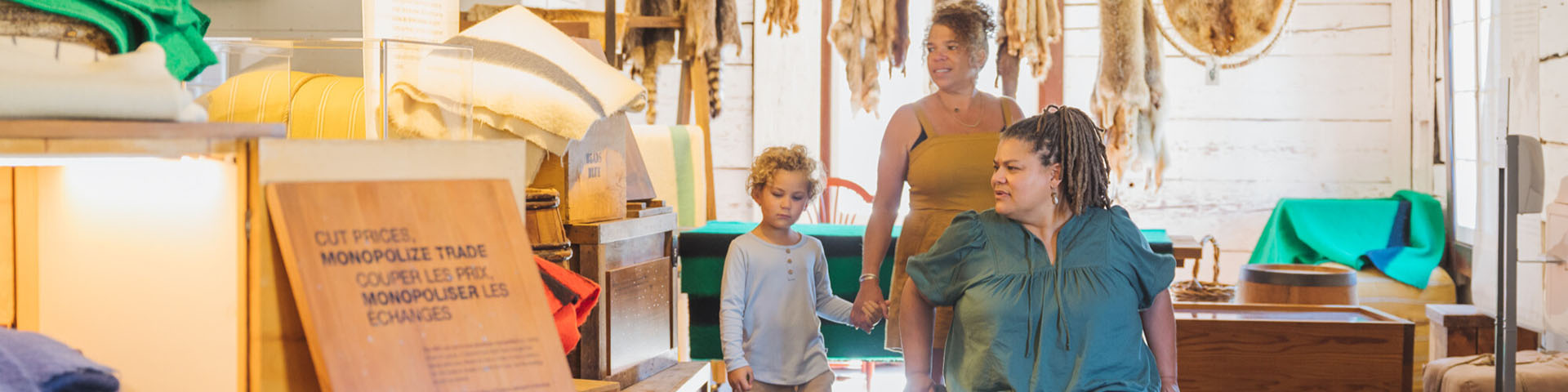 Two parents, one in a wheelchair, and their child exploring an exhibit inside the Storehouse.