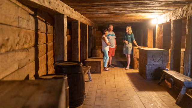 Une guide de Parcs Canada offre une visite guidée à un couple à l'intérieur d'une casemate.