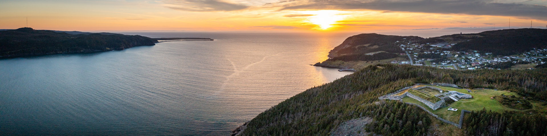 a historic star fort overlooking the ocean at sunset