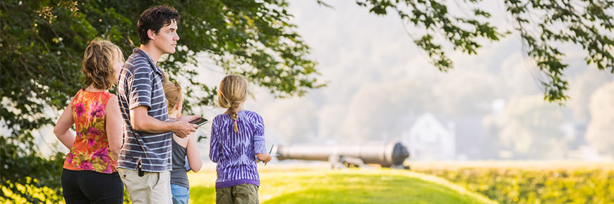 A family exploring the defensive banks, ditches, and bastions at Fort Anne National Historic Site.