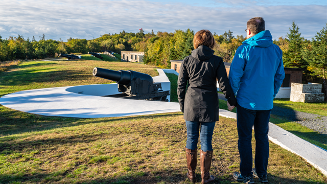 A couple next to a cannon.  