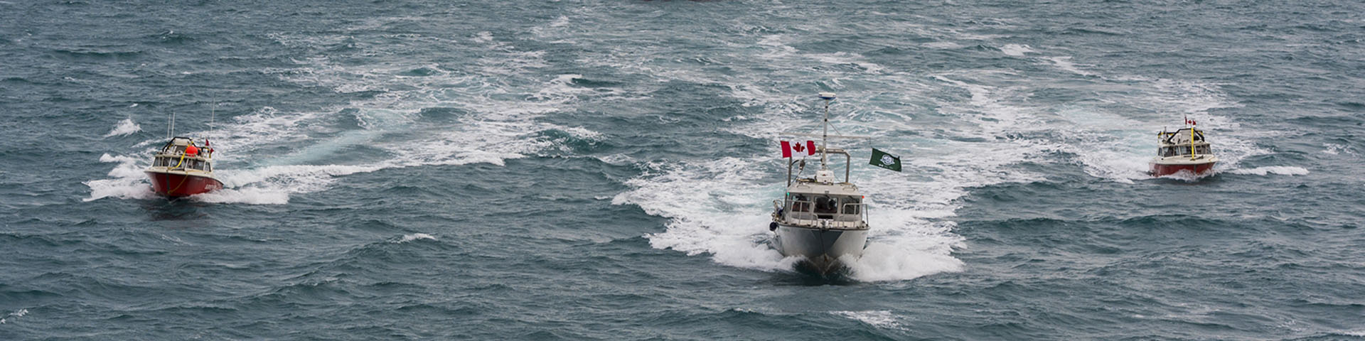 Three boats travelling across the water. 