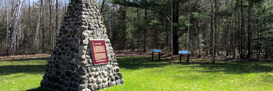 A stone cairn at a clearing in the forest. 