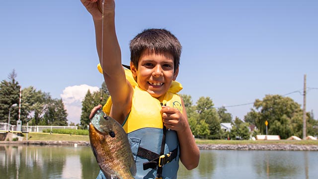 Proud child holding a freshly caught fish