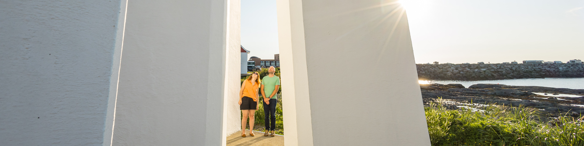 Two visitors at the foot of the lighthouse look up. 