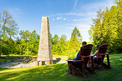 Sitting on the red chairs, a couple observes the vestiges of the lower forge