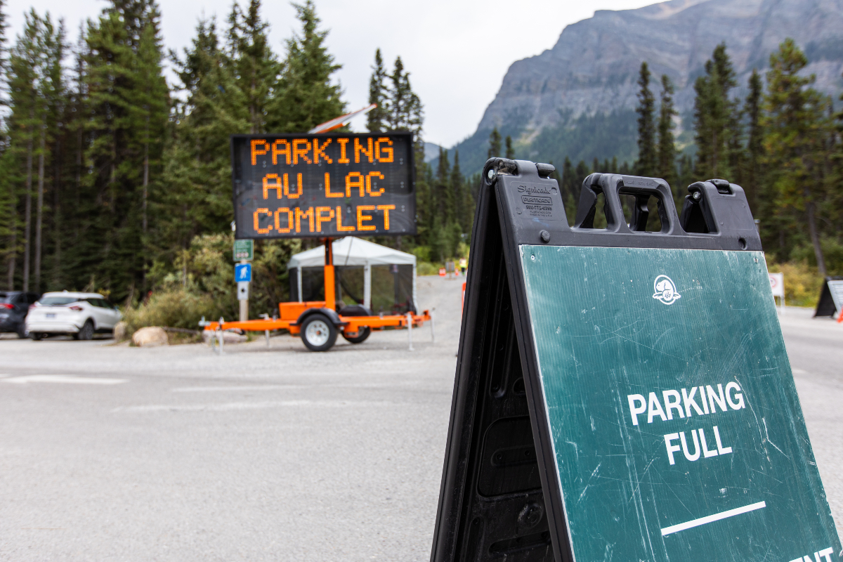 A sandwich board and electronic message board sign indicate that the parking lot is full.  