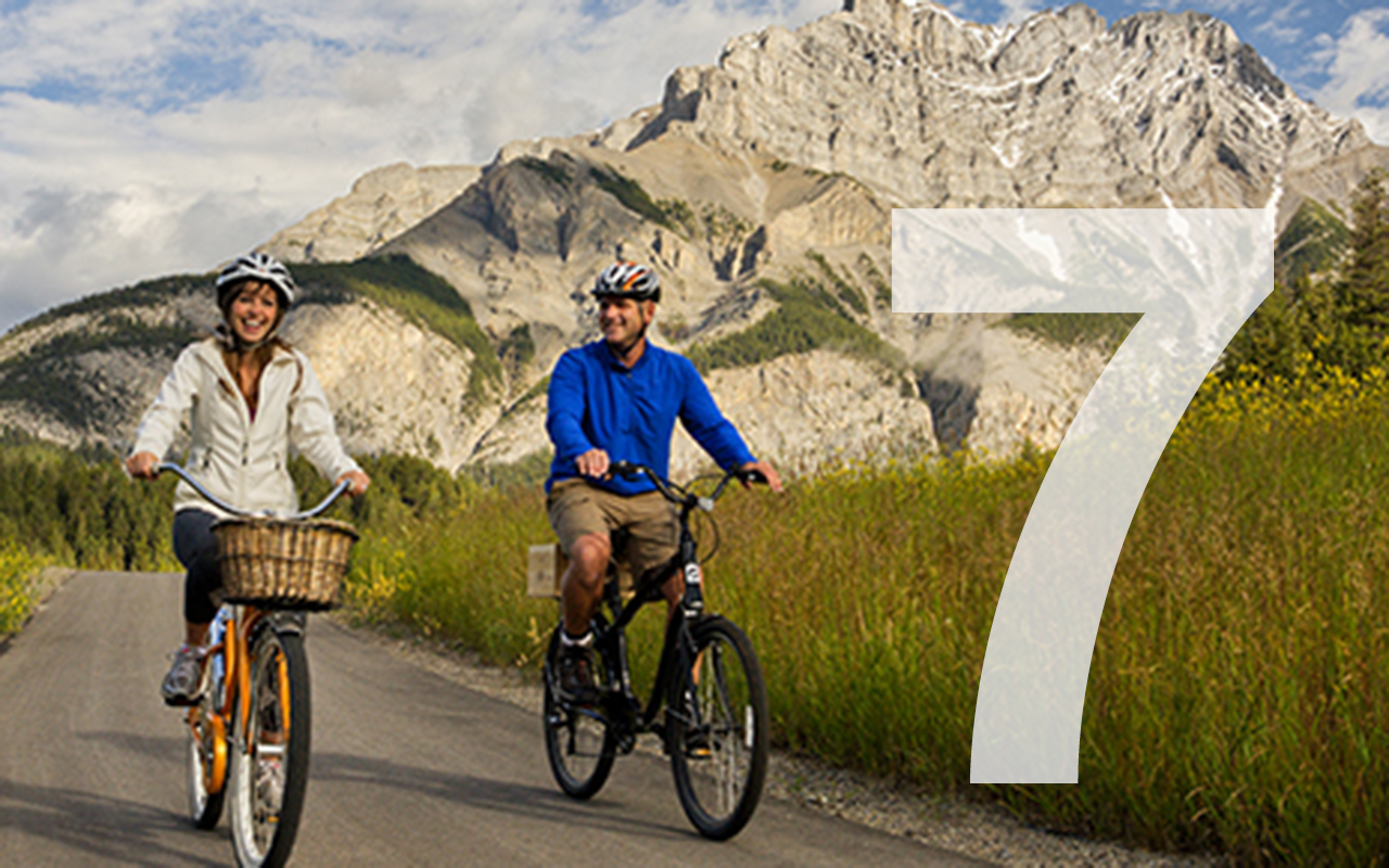 banff legacy trail from canmore to banff. couple riding and laughing 