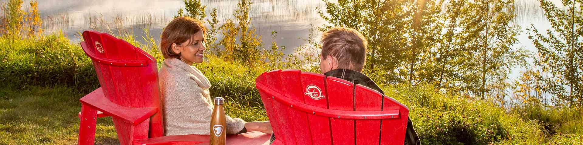 Visitors enjoy the view from the red chairs at the Bison Loop, Elk Island National Park.