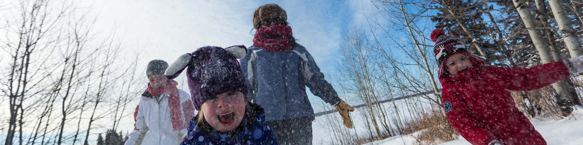 Une famille jouent au neige, parc national Elk Island