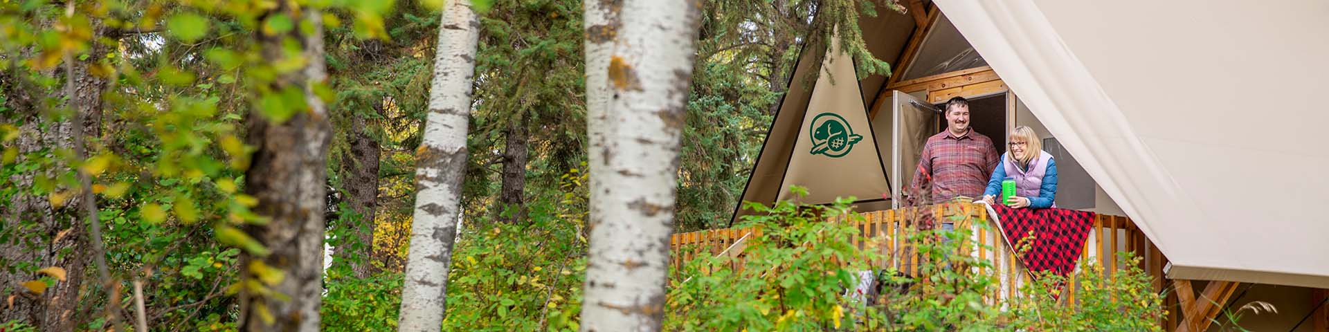 A couple look at the scenery from their oTentik at Astotin Lake Campground in Elk Island National Park.