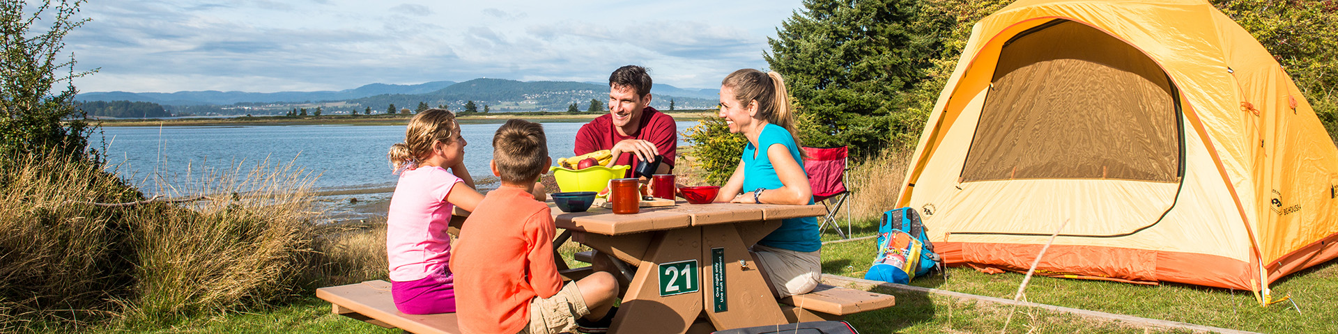 Campers enjoying the evening sun at the beachfront site at Sidney Spit