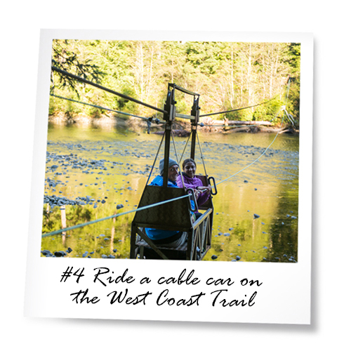 Two people in a cable car going across a large creek