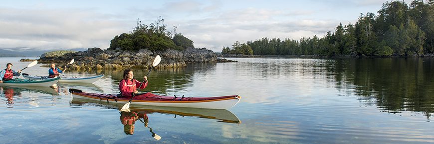 Three kayakers paddling through the Broken Group Islands