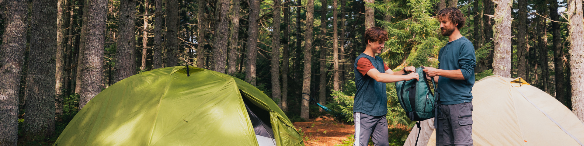 A father and son near their tents in the campground.