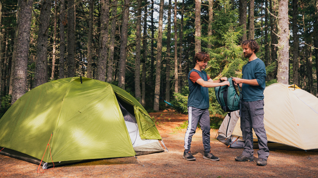 A father and son near their tents in the campground.