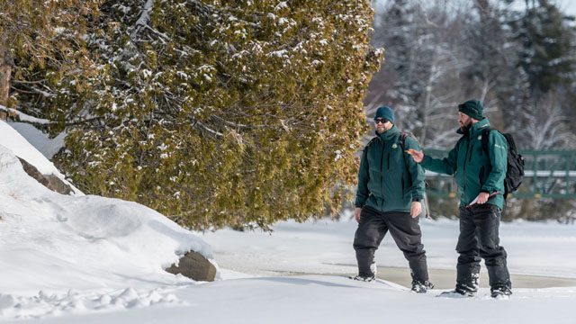 Des employés de Parcs Canada en conservation des ressources sur une rivière gelée.