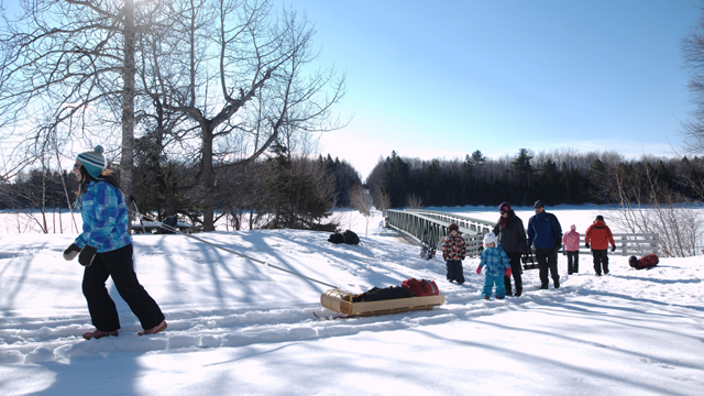 Une famille marche sur un sentier en hiver