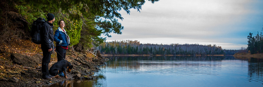 Un couple avec leur chien sur le bord d'une rivière