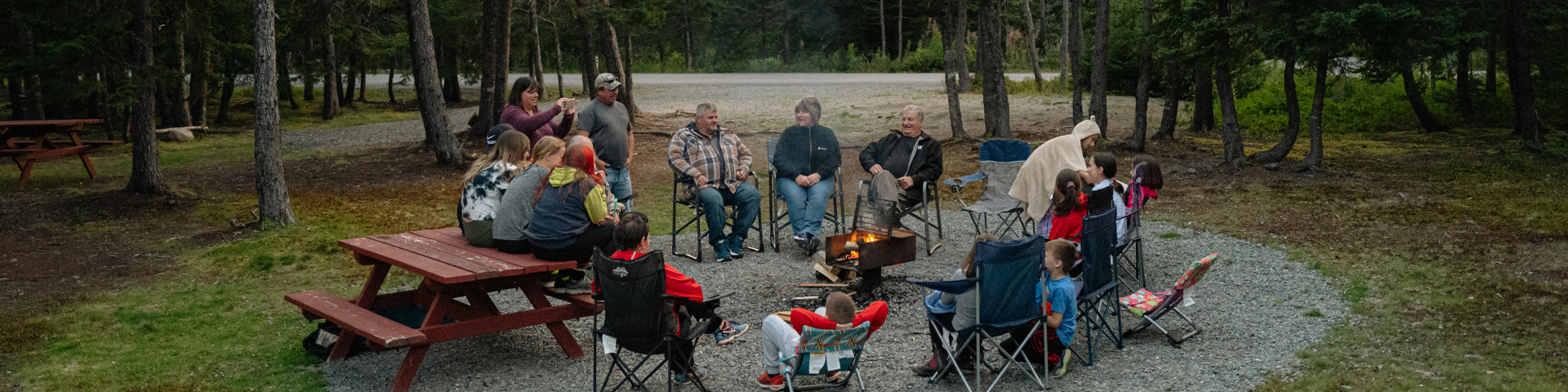 a group of people sitting around a campfire