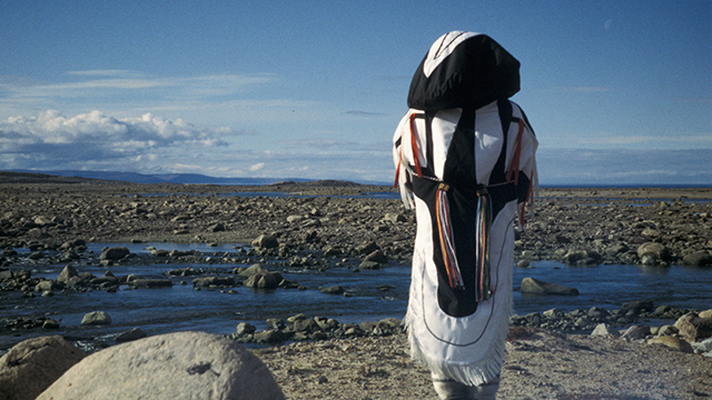 A person wearing an amauti overlooking a rocky river.