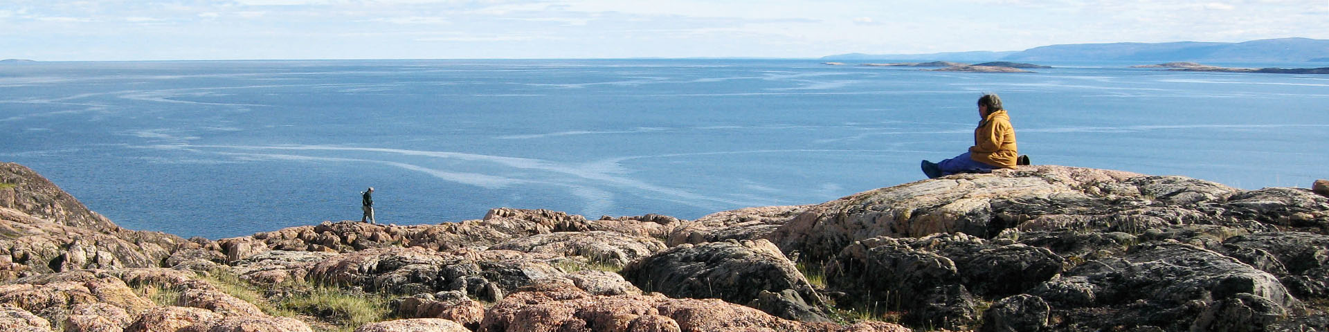 Une personne assise sur un rocher surplombant la baie de Wager. 