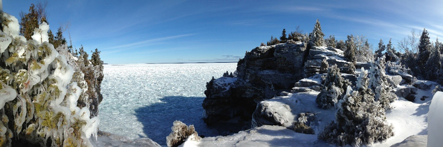 The shoreline covered in snow and ice. 