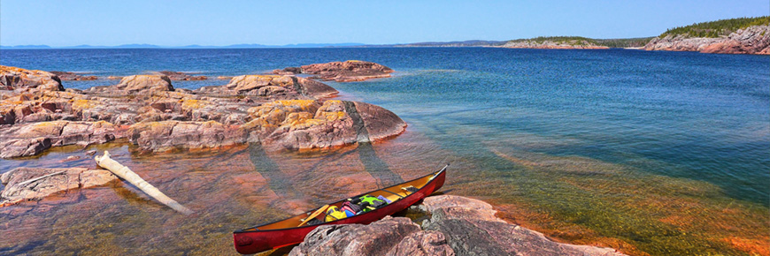 A canoe on a rocky shore.