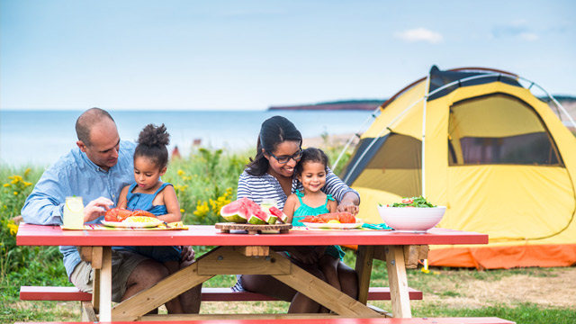 Family enjoying a picnic at Cavendish Campground, Prince Edward Island National Park.