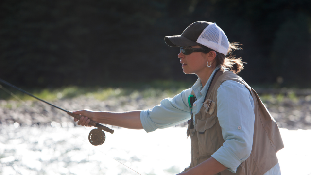 A woman is fly fishing.