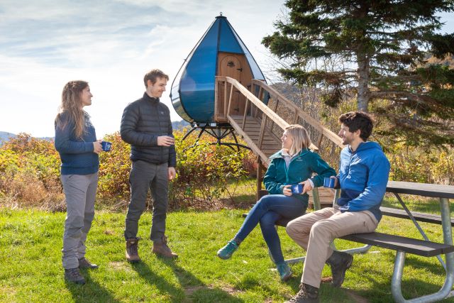 Four people chatting at the pic-nic table of an Oasis campsite