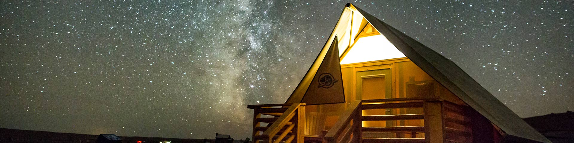 Parks Canada oTENTik below the Milky Way at night in the Dark Sky Preserve, in Grasslands National Park.