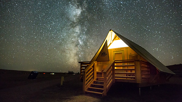 Parks Canada oTENTik below the Milky Way at night in the Dark Sky Preserve, in Grasslands National Park.