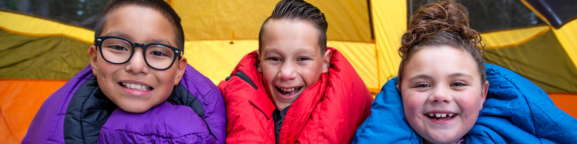 A family has fun at a campsite at Beaver Glen Campground in Prince Albert National Park.