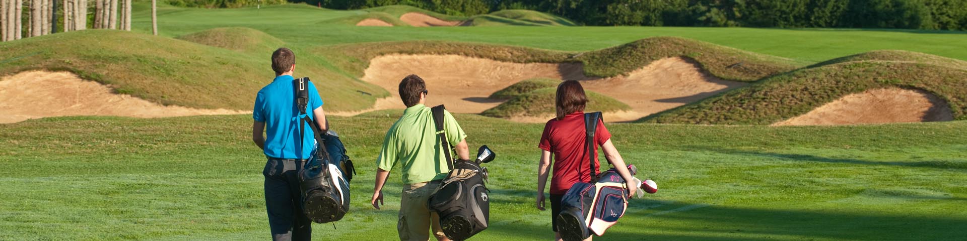 Golfers at the Green Gables Golf Course with Cavendish Beach in the distance