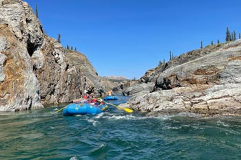 Two rafts descending the Firth River in a rocky section at Ivvavik National Park.