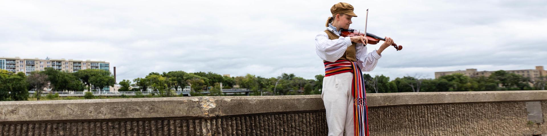 Female costumed interpreter posing with her fiddle.