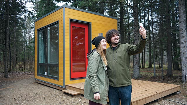 Deux jeunes adultes prennent un égoportrait devant un MicrOcube au parc national du Mont-Riding.